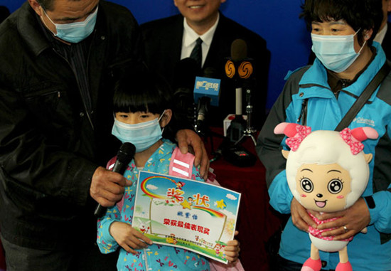 The first H7N9 bird flu patient in Beijing, a girl surnamed Yao, accompanied by her parents, receives a certificate from Ditan Hospital for her brave composure during her hospitalization there. Yao was discharged on Wednesday. Wang Jing / China Daily