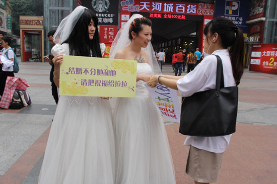 Xiaoxiao and Xiaoyang ask for blessings from a passer-by. The lesbian couple hosted their wedding in Guangzhou on Wednesday. [Provided to China Daily]