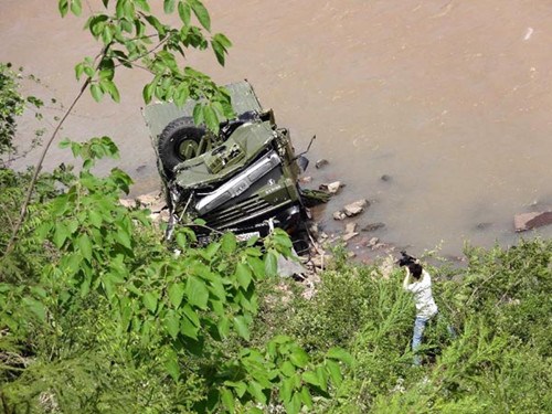 A cameraman takes video footage of a destroyed truck in Ya'an of southwest China's Sichuan Province, April 20, 2013. A truck carrying 17 soldiers plunged down a roadside cliff and fall into a river at 12:40 a.m. Beijing time (0440 GMT) on its way to the rescue mission in the earthquake-hit Lushan County in Sichuan Province, leaving one soldier dead, three seriously injured and other four with minor injuries.(Xinhua)