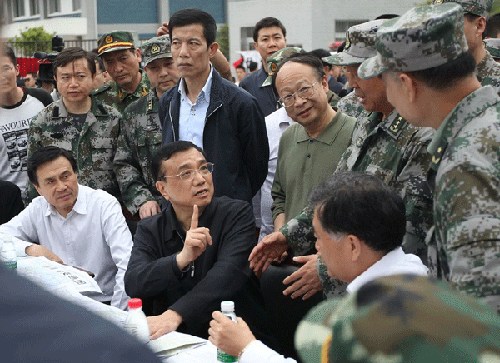 Premier Li Keqiang, center, calls a meeting at the front-line headquarters in Longmen Township of Lushan, April 20, 2013. [Photo by Zhang Xiaoli/Asianewsphoto]