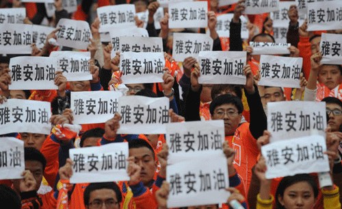 Spectators raise up banners reading, Ya'an stays strong, for the people in the quake-hit area during a Chinese Super League soccer game in Jinan city, East China's Shandong province on April 20, 2013.[Photo/Xinhua]