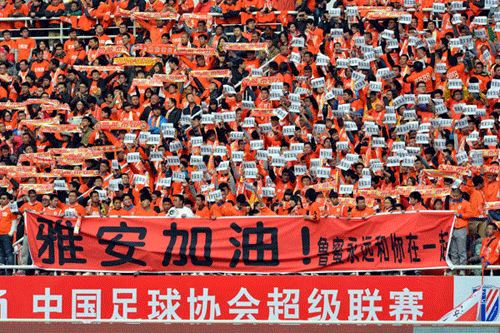 Spectators raise up banners reading, Ya'an stays strong, for the people in the quake-hit area during a Chinese Super League soccer game in Jinan city, East China's Shandong province, on April 20, 2013. [Photo/Xinhua]