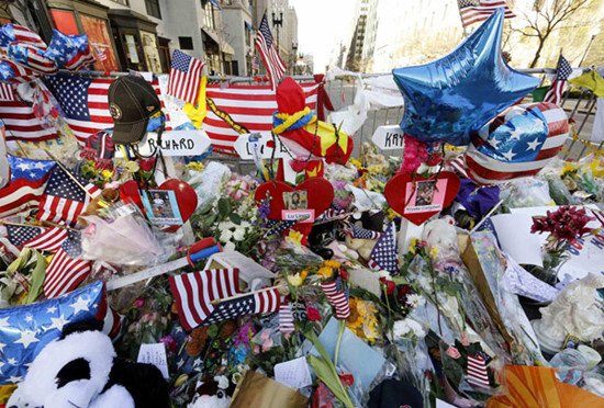 Three crosses representing Boston Marathon bombing victims Lu Lingzi, Martin Richard and Krystle Campbell have been placed at a memorial to the victims of the blasts near the scene of the bombings on Boylston Street in Boston, Massachusetts, April 21, 2013. [Photo/Agencies]