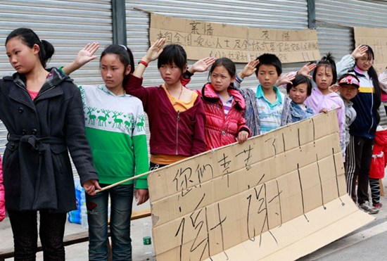 Students in Longmen town, Lushan county, welcome rescue vehicles on Monday. FENG YONGBIN / CHINA DAILY