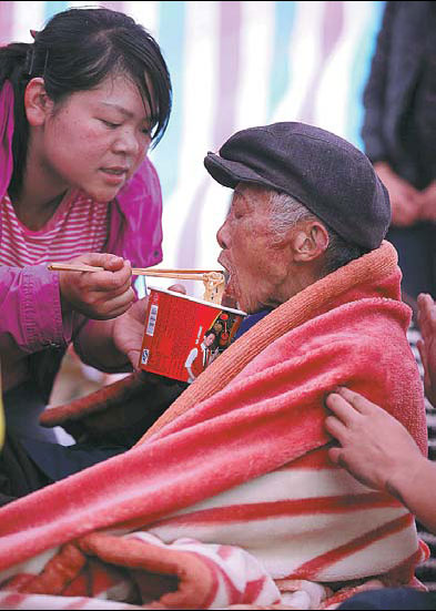 A volunteer feeds 86-year-old Wu Renchi.