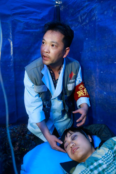 Shen Yongkang, 34, a doctor at People's Hospital of Wenchuan County, Sichuan province, treats a patient injured in the earthquake in Lushan county. FENG YONGBIN / CHINA DAILY