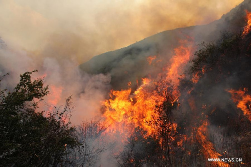 Photo taken on April 26, 2013 shows the scene of a forest fire in Qinfeng Township of Lufeng County, southwest China's Yunnan Province. Over 2,200 firefighters and service men have been mobilized to fight against a forest fire which broke out at around 16:00 (0800 GMT) on April 23. As of 16 p.m. on Friday, part of the burning area have been under control. (Xinhua/Xu Tao)