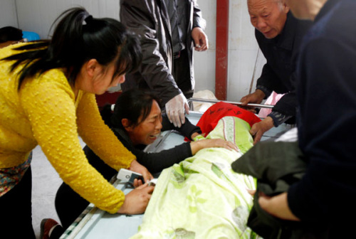The family of a 5-year-old girl grieve over her body at a morgue in Pingshan county, Hebei province, on Wednesday. The girl died from yogurt poisoning after a week of medical treatment. Provided to China Daily