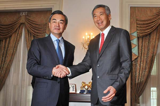 Foreign Minister Wang Yi (left) shakes hands with Singaporean Prime Minister Lee Hsien Loong during a meeting at the Istana presidential palace in Singapore on Friday. Wang was on a two-day visit in Singapore, his first official visit as foreign minister. MOHD FYROL / Agence France-Presse