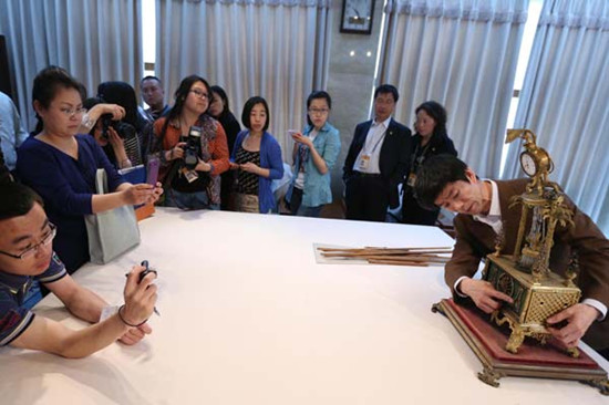 Guo Fuxiang, a researcher at the Palace Museum, briefs reporters about a gilded brass clock that was damaged by a tourist. The man smashed a window in the Palace of Blessings to Mother Earth in the Palace Museum on Saturday, causing the antique clock to fall. Photo by Lin Hui / For China Daily 