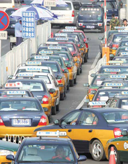 With the taxi business fragmented among many companies in Beijing, the city government is standardizing hotlines, a website and mobile phone apps for advance booking. [Wu Changqing / for China Daily]