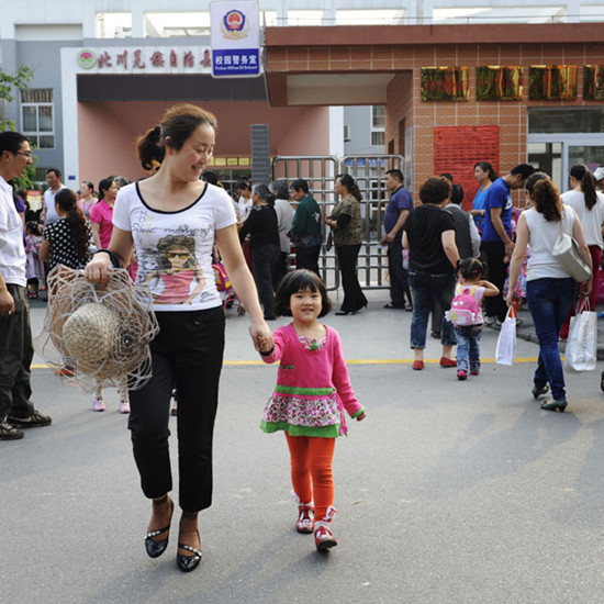 Qiao Zhenzhen picks up her daughter from a kindergarten in Beichuan county of Sichuan province on May 3, 2013. Qiao, 34, gave birth to her daughter, Yang Yuge, on June 24, 2009. She lost her only 8-year-old son in the 2008 earthquake. [Pan Songgang and Duan Xuemei/Asianewsphoto]