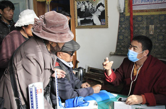 Ngawang Thayi, 39, a Buddhist monk who is a doctor specializing in Tibetan and Western medicine, answers patients' questions in the clinic of Drepung Monastery, in Lhasa, the Tibet autonomous region. The ancient practice is becoming less common with changes in science. Photo by Wang Huazhong / China Daily