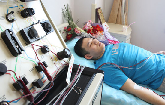 Wang Yuanxiang in Changchun, Jilin province, donates blood stem cells for a 37-year-old leukemia patient on Monday. Wang, a 24-year-old student at the Jilin Institute of Physical Education, has been a regular blood donor for six years. [Photo by Sheng Xuesong/For China Daily]