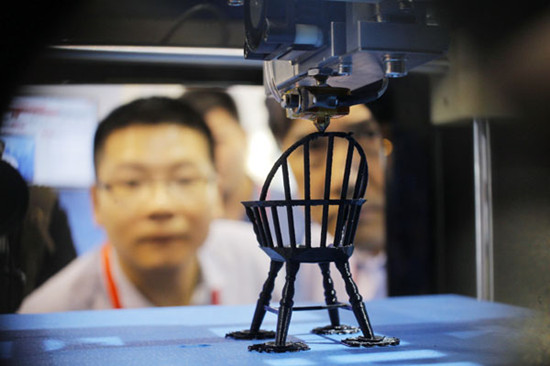 A visitor admires a model of a chair being printed on a 3-D printer at the China (Shanghai) International Technology Fair in Shanghai on Wednesday. Gao Erqiang / China Daily