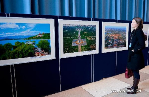 A visitor looks at pictures on display during an exhibition promoting tourism of Chinese capital city Beijing, at the United Nations headquarters in New York, on May 8, 2013. (Xinhua/Niu Xiaolei)  