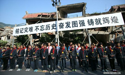 Pupils mourn for victims who died in a massive earthquake five years ago in the old county seat of Beichuan, southwest China's Sichuan Province, May 12, 2013. A memorial event was held in Beichuan on Sunday to mark the fifth anniversary of the deadly earthquake which havoced Sichuan on May 12, 2008. (Xinhua/Wang Shen) 