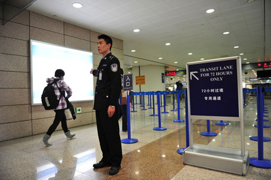 A police officer directs transit passengers through the 72-hour visa-free lane at Shanghai Pudong International Airport. Transit passengers from 45 countries have been allowed to stay in the city for 72 hours without a visa since January. YANG XIAJIE / XINHUA