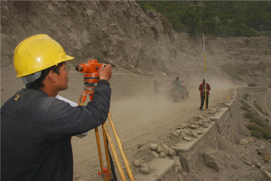 Workers survey the road on the Karakoram Highway construction site in northern Pakistan, May 13, 2013. [Photo/Xinhua]