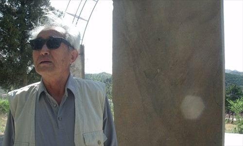 Peng Mingsheng stands by a monument at a hillside in Chengde, Hebei Province, which marks the mass grave of 36,000 people killed during the Japanese occupation from 1933-45 in the city. Photo: Zhang Yiwei/GT