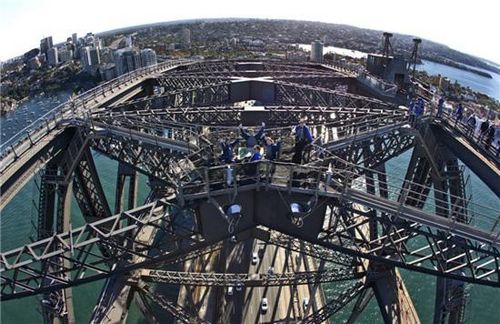 Tony Liu, Ling Khor, Jak Heng and Pauline Heng wave as they play the traditional Chinese board game 'mahjong' on top of the Sydney Harbour Bridge during a  promotional event in Sydney May 15, 2013, in this picture provided by Bridgeclimb. Sitting 134 metres above sea level, the game was held to promote The Mandarin Climb tours during which visitors can climb to the top of the iconic bridge with the assistance of Mandarin-speaking guides. Sydney will also host the World Series of Mahjong from June 2 to 4. [Photo/Agencies] 