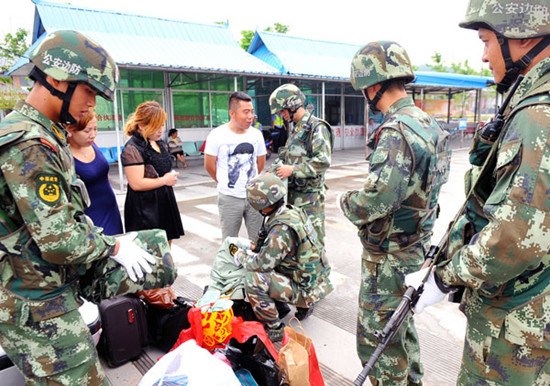 Border police inspect luggage at a checkpoint in the Xishuangbanna Dai autonomous prefecture, Yunnan province, on May 15. Photo by Chen Haining / Xinhua
