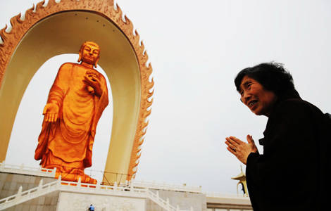 A woman prays in front of the Buddha statue in Jiujiang, East China's Jiangxi province, May 19, 2013. [Photo by Xi Yan/Asianewsphoto] 