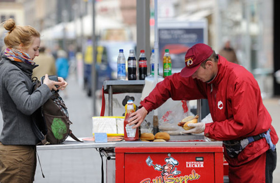 A vendor prepares and sells bratwurst in Leipzig, Germany. Photos by STEVE HUI ZHAO / FOR CHINA DAILY