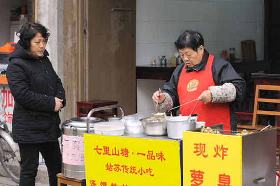 A vendor cooks and sells turnip strip cakes, a traditional food in Suzhou, Jiangsu province. Photos by STEVE HUI ZHAO / FOR CHINA DAILY