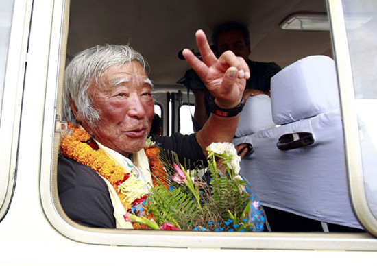 Japanese mountain climber Yuichiro Miura, 80, shows a victory sign upon his arrival at the airport after climbing Qomolangma, in Kathmandu, May 26, 2013. Miura, who has had four heart surgeries, reached the top of Qomolangma on Thursday becoming the oldest person to conquer the world's highest mountain. Miura, who first climbed Qomolangma in 2003 and repeated the feat five years later, takes the oldest climber record from Nepal's Min Bahadur Sherchan, who reached the summit at the age of 76 in 2008.[Photo/Agencies]