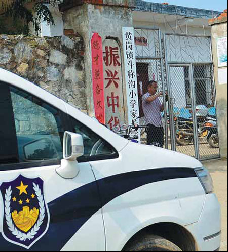 A police car is parked outside the parenting training center run by a primary school in Nanyang, Henan province, on Monday as officers continue an investigation. Yang Shifu, a teacher at the school, was detained on Thursday on suspicion of molesting female students. Xiang Mingchao / China Daily