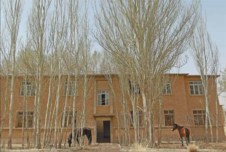 The remains of Malan military base in the Xinjiang Uygur autonomous region have become a home for herdsmen. Below: Local resident Aoriliman, 29, enters the former command office at the base. Photos by Cui Meng / China Daily