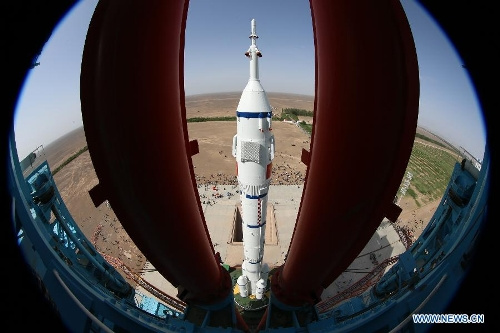 Photo taken on June 3, 2013 shows the assembly of the Shenzhou-10 spacecraft and the Long March-2F carrier rocket at Jiuquan Satellite Launch Center in Jiuquan, Northwest China's Gansu Province. The assembly was transported to the launch site on Monday morning, which marks the manned Shenzhou-10 mission entering the final phase of its preparation. The spacecraft, which will be launched in mid-June from the Jiuquan Satellite Launch Center, will carry three astronauts and dock with Tiangong-1, target orbiter and space module. (Xinhua/Qin Xian'an) 