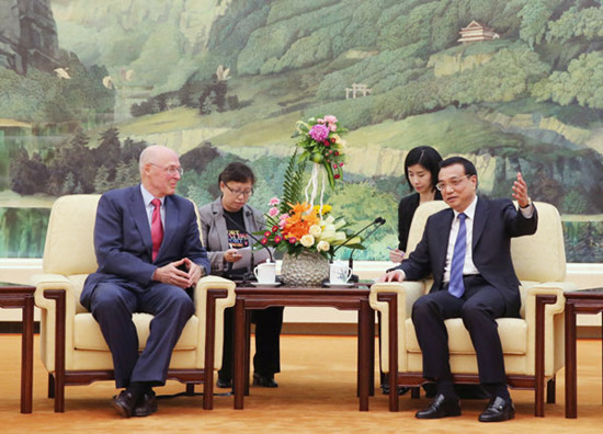 Premier Li Keqiang meets with visiting former US treasury secretary Henry Paulson in Beijing on Wednesday. Xu Jingxing / China Daily