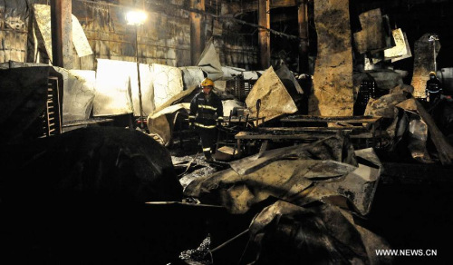 A fire fighter searches for survivors at the burnt poultry slaughterhouse owned by the Jilin Baoyuanfeng Poultry Company in Mishazi Township of Dehui City in northeast China's Jilin Province, June 3, 2013. The death toll from the fire has risen to 120 as of 8 p.m. on Monday. Search and rescue work is under way. (Xinhua/Wang Haofei)