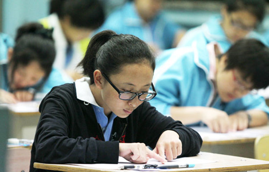 Students work on their exams at the exam site of Beijing Tibet Middle School in Beijing on Friday. Zhu Xingxin / China Daily