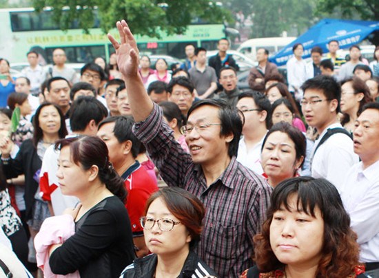 Family members of students wait anxiously outside the exam site at the High School Affiliated to Renmin University of China in Beijing on Friday. About 9.12 million applicants are expected to take this year's national college entrance exam on Friday and Saturday. Cui Meng / China Daily