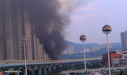 A bus bursts into flames on an elevated track near the Jinshan bus stop in the city of Xiamen, southeast China's Fujian Province, June 7, 2013. An initial investigation showed the fatal bus fire that has claimed 47 lives and hospitalized 34 on Friday was suspected to be a serious criminal case. (Xinhua)
