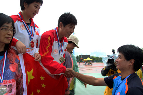 He Xin, who underwent a liver transplant in 2006, accepts a medal in a sports meeting for organ transplant recipients in Hong Kong in November. PROVIDED TO CHINA DAILY 