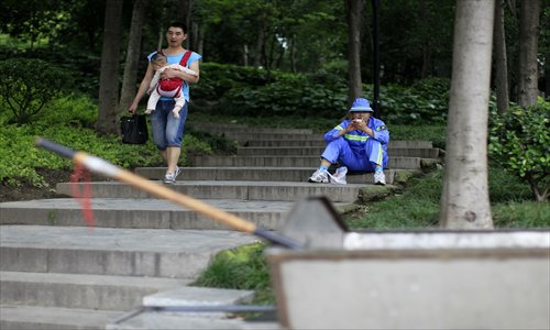 A sanitation worker takes a break Wednesday on the stairs of a public park near Chengdu Road South and Changle Road. Photo: Cai Xianmin/GT