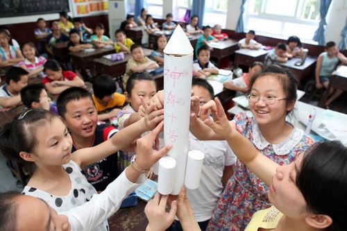 Primary students in Chongqing display their hand-made model of the Shenzhou X spacecraft on Thursday.Chen Shichuan / For China Daily 