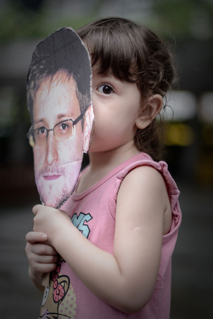 A child holds a cutout of Edward Snowden during a protest in support of the whistleblower in Hong Kong yesterday. [Agencies]