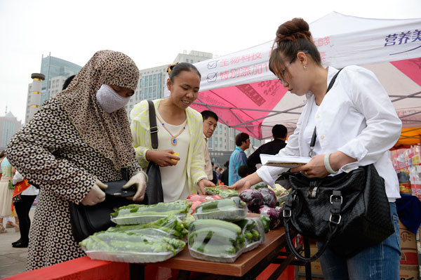 Residents of Yinchuan, Ningxia Hui autonomous region, learn how to distinguish organic vegetables at a food safety exhibition on Monday. WANG PENG / XINHUA