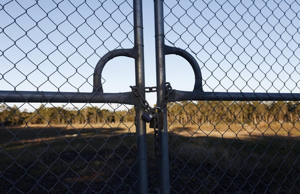 A padlock is seen on a fence on the land where a a full-size replica of Beijing's Forbidden City will be built, in the Wyong region near Sydney June 16, 2013. Australia's coastal Wyong region outside Sydney, a pretty stretch of pristine beaches and wildlife-filled wetlands, isn't high on the travel agenda of most Chinese tourists. But the local mayor and a Chinese businessman have big plans to change that - by building a A$500 million ($480 million) theme park that will include the Forbidden City replica and a nine-storey temple housing a giant Buddha. Picture taken June 16, 2013.[Photo/Agencies]