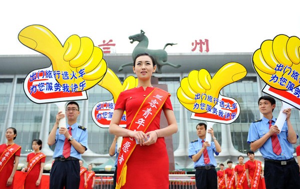 Chen Xiaoxue (middle), the champion of Miss Tourism International 2012, leads a group of coach attendants who are ready to depart on June 18, 2013 from the railway station square in Lanzhou city. [Photo / Xinhua]