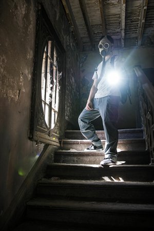 Urban explorer Zhao Yang wears a gas mask as he delves into the abandoned No.81 house, situated right on busy Chaoyangmennei Dajie. Photo: Li Hao/GT