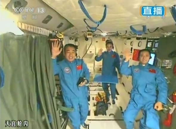 This video grab shows China's three astronauts wave their hands and send best regards to students back on the Earth at the end of the country's first space class. (Photo: CNS)