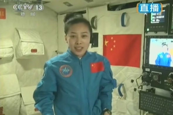 Female astronaut Wang Yaping gives a lecture to about 330 primary and middle school students, through a live video feed system about 340 km above the Earth, on June 20, 2013. (Photo: CNS)