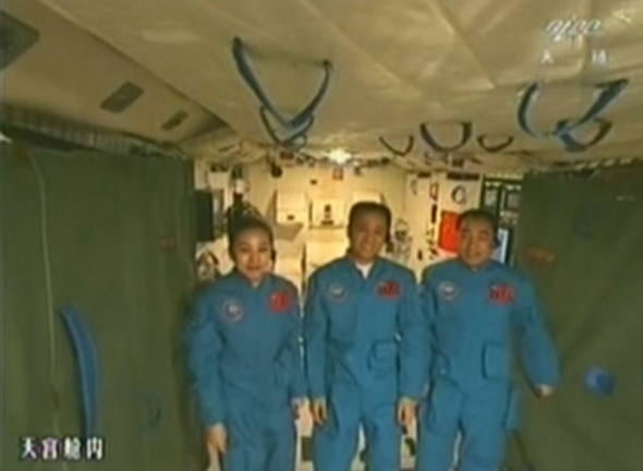This TV grab taken on June 24, 2013 shows astronauts aboard Tianggong-1 space lab module. President Xi Jinping came to the Beijing Aerospace Control Center on Monday morning to talk with the astronauts who are conducting scientific tests in Tiangong-1. [Photo: CCTV] 