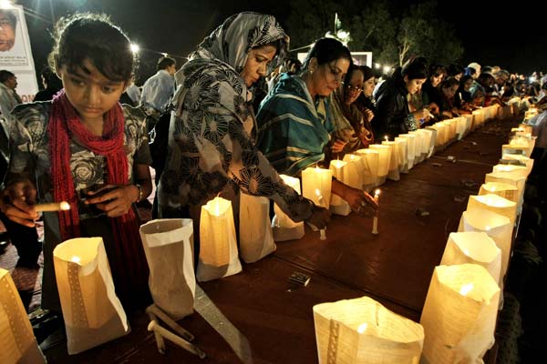 Workers of the Pakistani political party Muttahida Qaumi Movement light candles to commemorate victims slain by militants, in Karachi, Pakistan, on Sunday. Islamic militants wearing police uniforms shot and killed 10 foreign tourists and one Pakistani guide. Fareed Khan / Associated Press 
